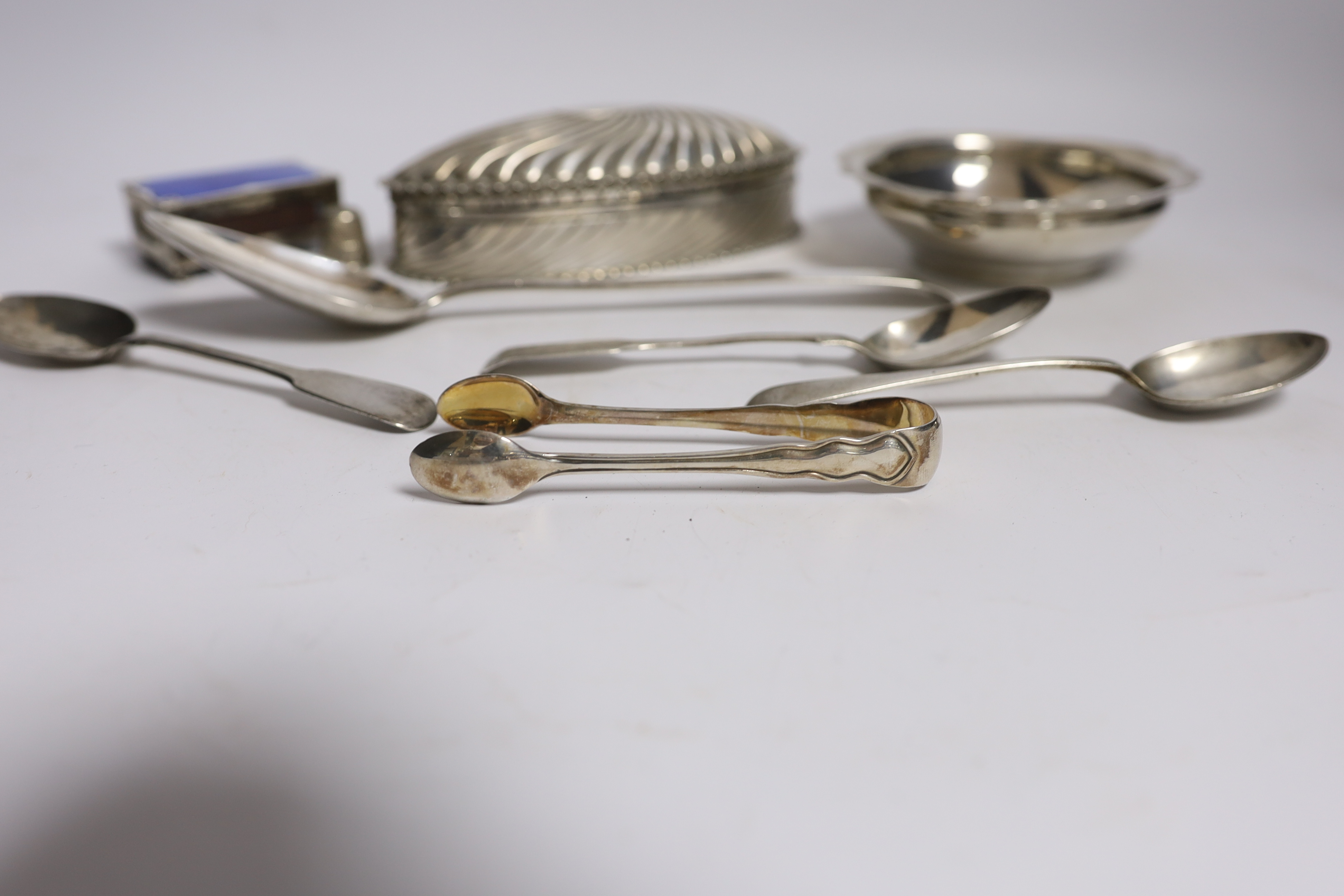 A late Victorian repousse silver oval trinket box by Horton & Allday, Birmingham, 1890, 15.2cm, together with five items of silver flatware, a silver bowl, silver and enamel matchbox sleeve and a sterling thimble.